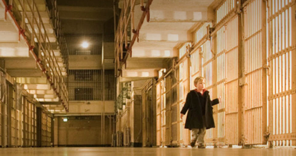 Boy walking in prison hallway 