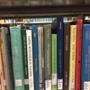 BA06CE01-D3C0-4DB1-B089-BC6378DCF463: a shelf full of books on teacher stress, at a university library.